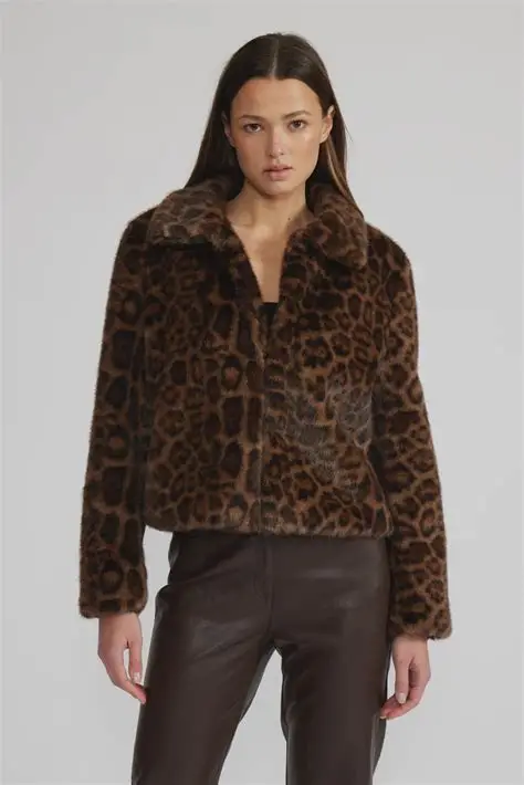 Woman wearing a leopard print jacket on a plain background