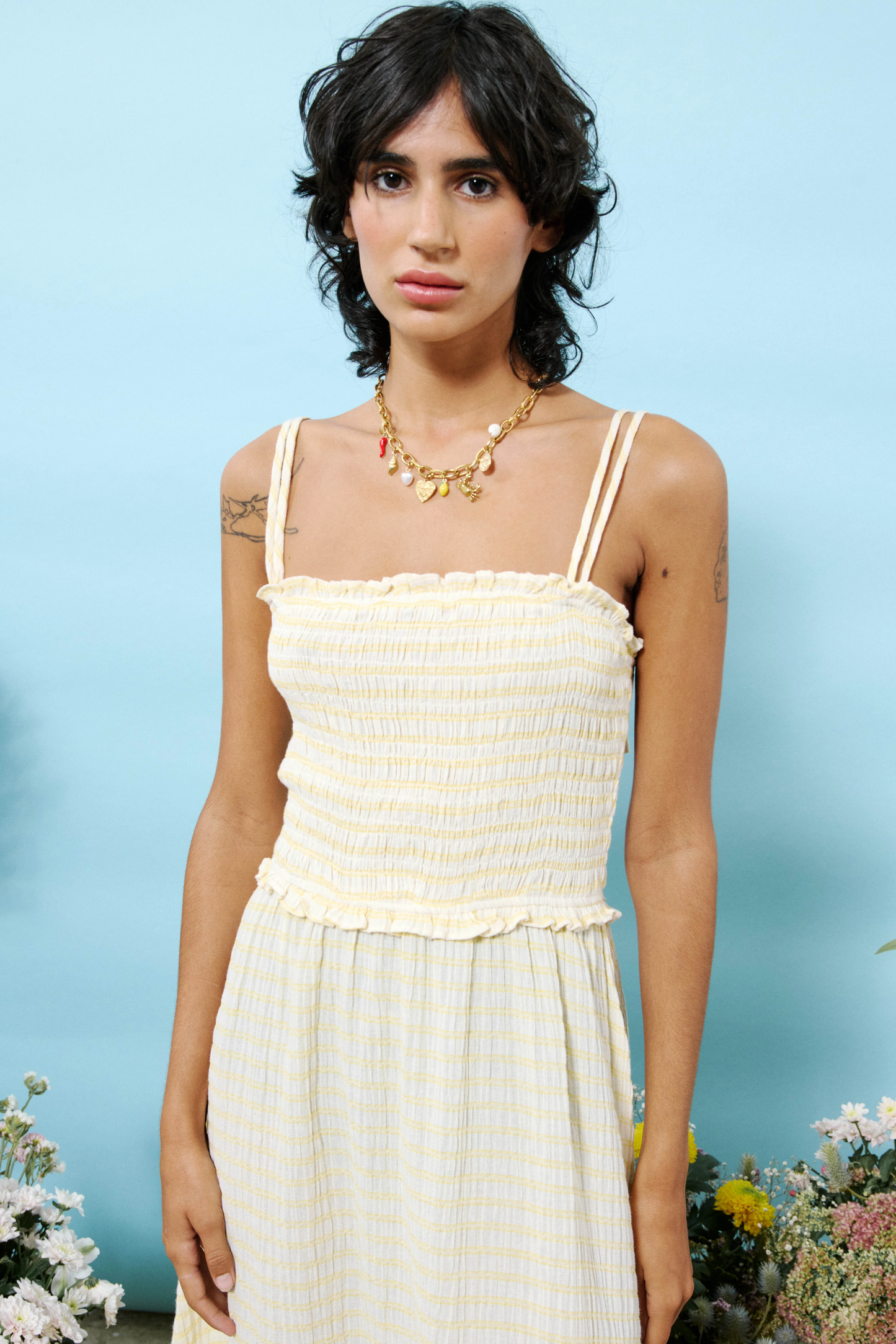 Woman wearing a light-colored dress with floral decorations in the background