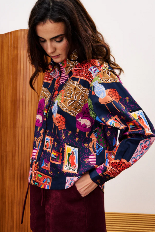 Woman wearing a colorful patterned jacket against a neutral background