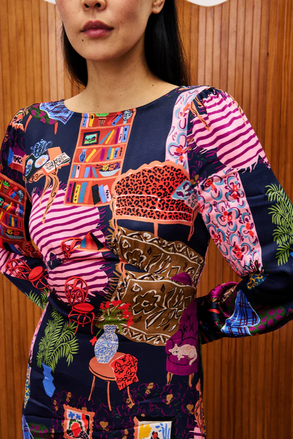Person wearing a colorful patterned dress with a wooden background