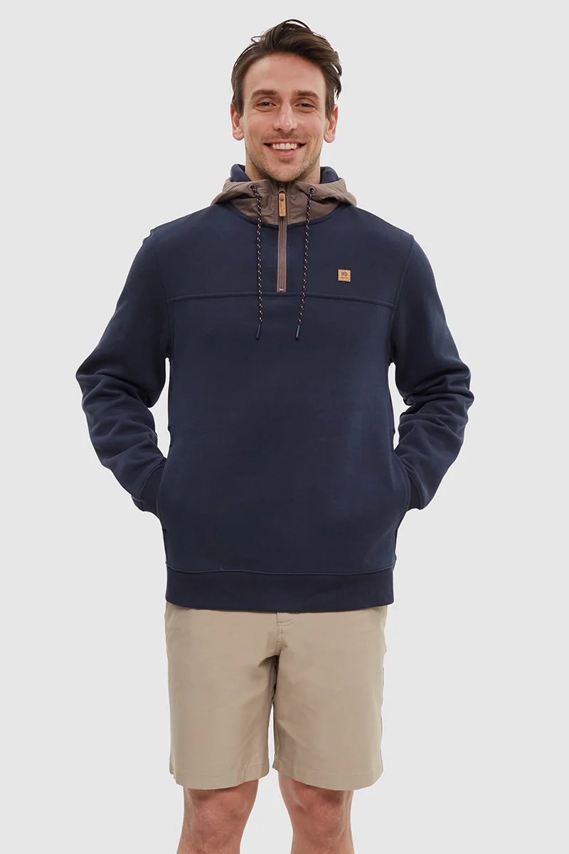 Man wearing a navy pullover with a hood and beige shorts on a white background