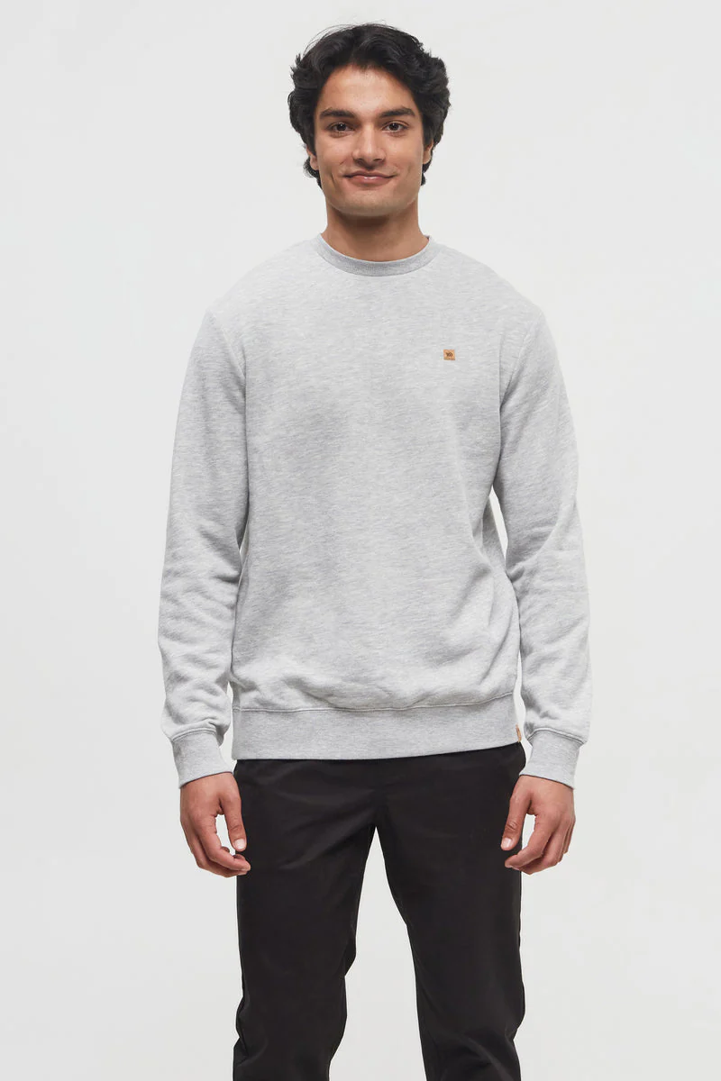 Man wearing a gray sweater with a small logo on a white background