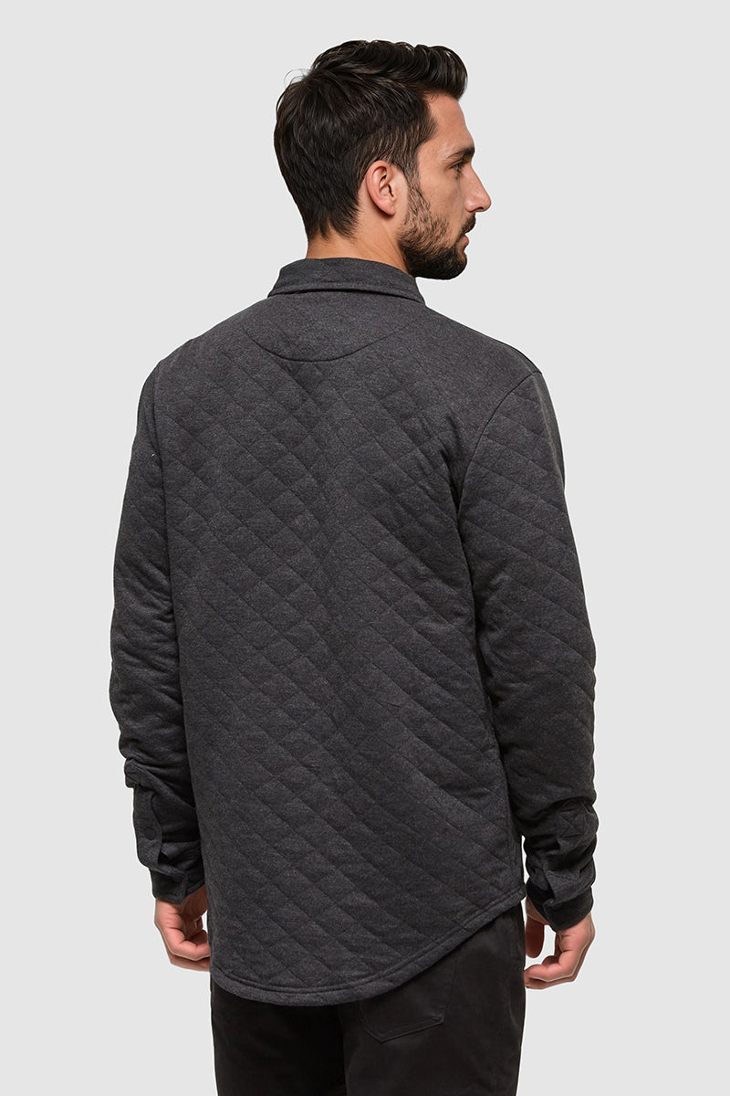 Man wearing a dark gray quilted jacket on a light gray background