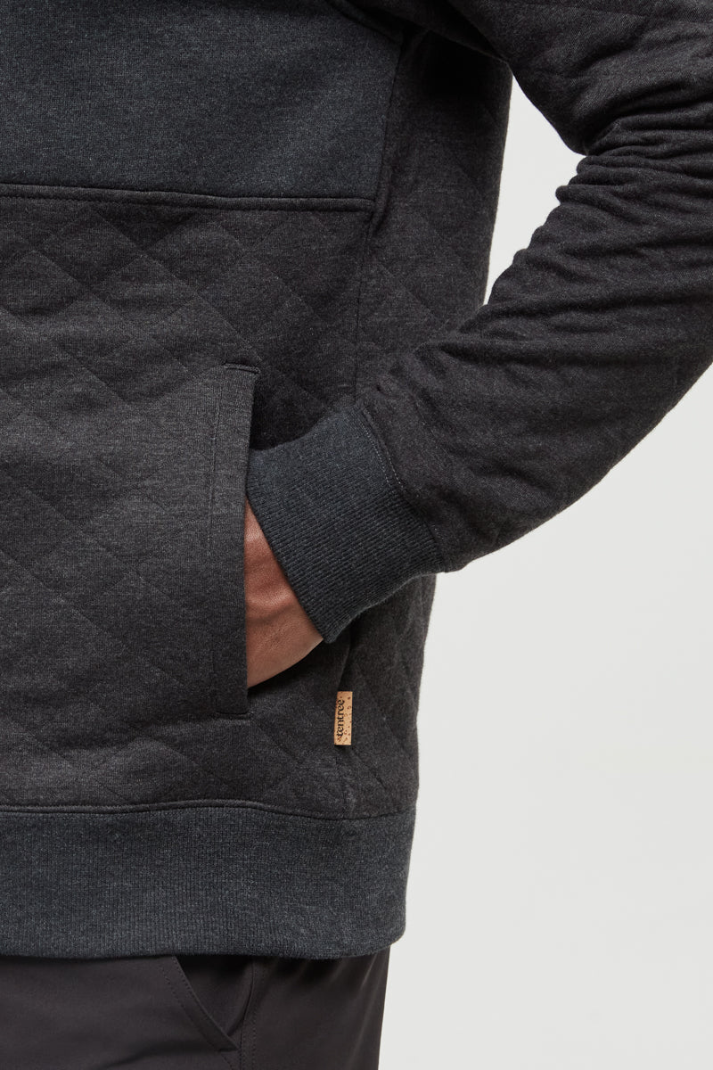 Dark gray quilted jacket with a brand logo on a light gray background