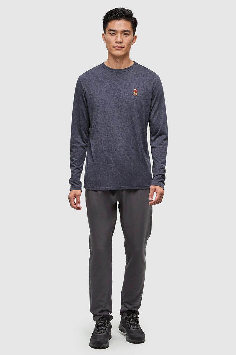 Man wearing a dark long-sleeve shirt and gray pants on a white background
