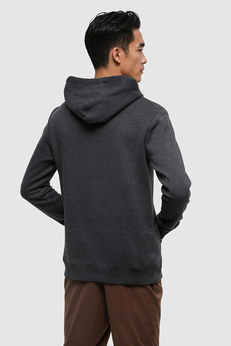 Person wearing a dark gray hoodie on a light gray background