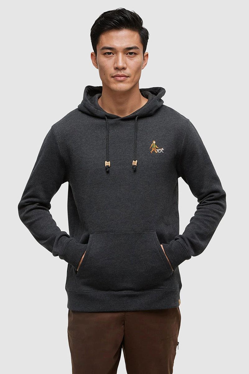 Man wearing a dark gray hoodie with a logo on a light gray background