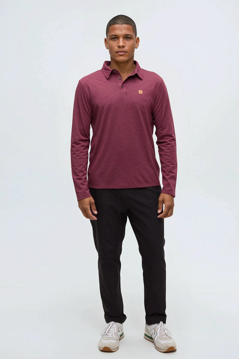 Man wearing a maroon long-sleeve shirt and black pants on a white background