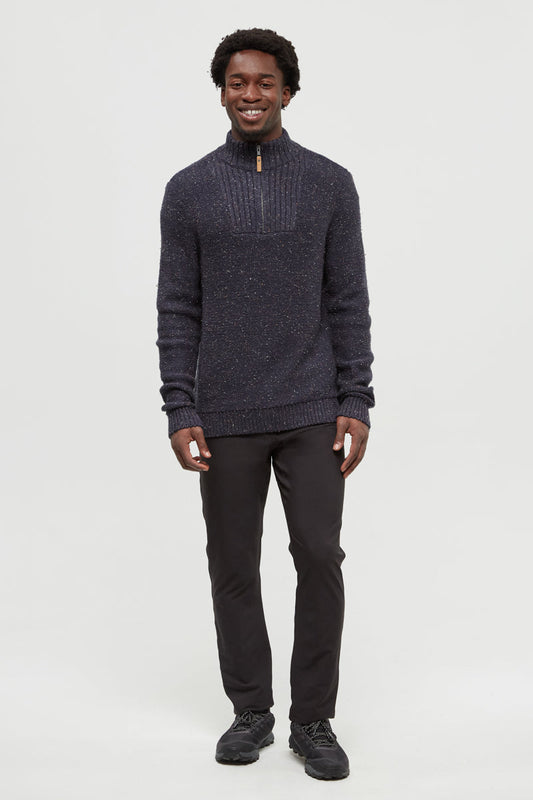 Man wearing a dark gray sweater and black pants on a white background