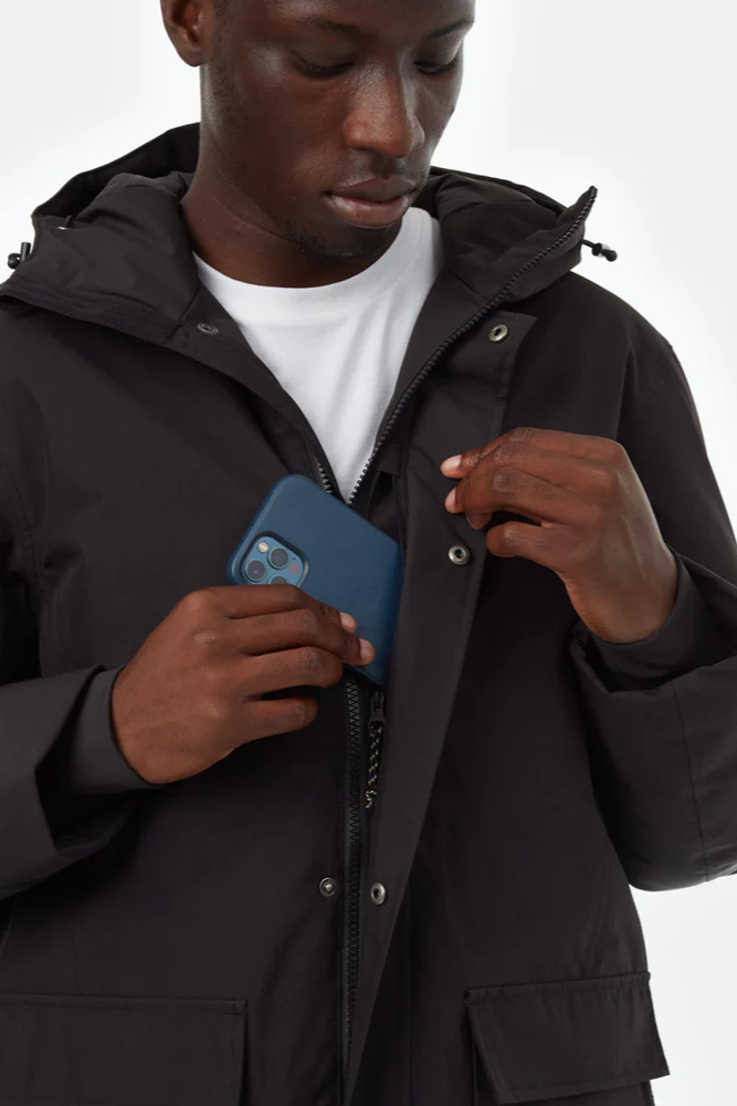 Person wearing a black jacket holding a blue phone case against a white background