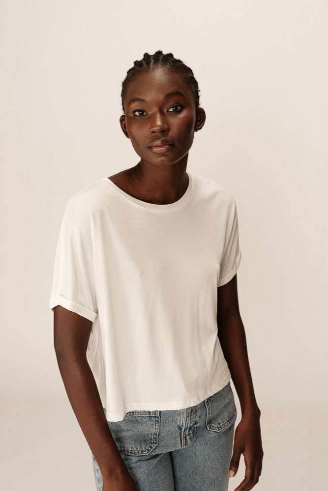 Person wearing a white t-shirt and blue jeans against a plain background