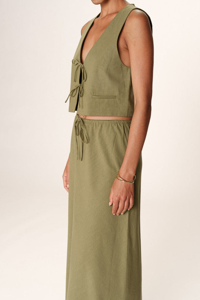 Woman wearing a green sleeveless jumpsuit on a white background