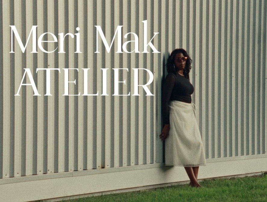 Load video: Meri Mak Atelier fashion video featuring a black satin-lapel suit, a white satin-lapel suit, a silk organza skirt, a black strapless dress with a sheer underlay, and a sheer top. The looks are modelled at Goldie Mill and on a bridge near the Guelph courthouse overlooking the water.