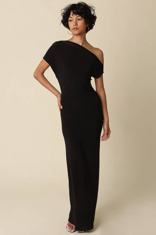 Woman wearing a black one-shoulder dress against a beige background